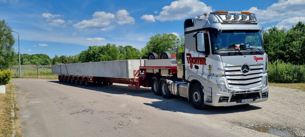 Schwertransport eines langen Betonfertigteils auf einem Spezialauflieger