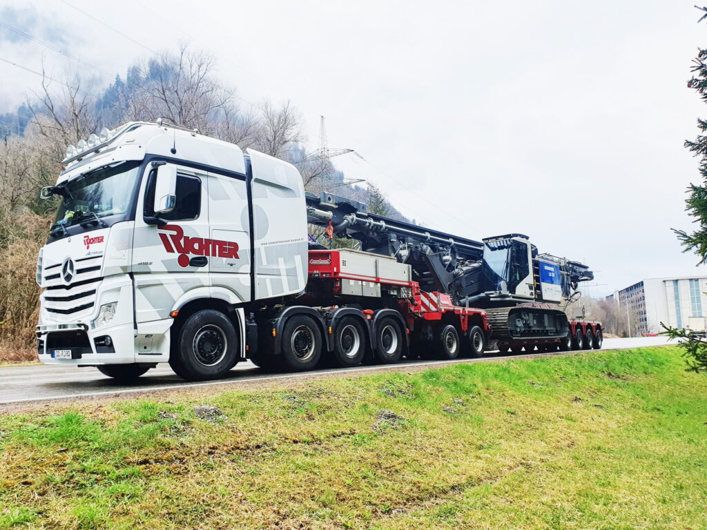 Baumaschinentransport eines Raupenbohrgeräts auf einem Tiefbettauflieger