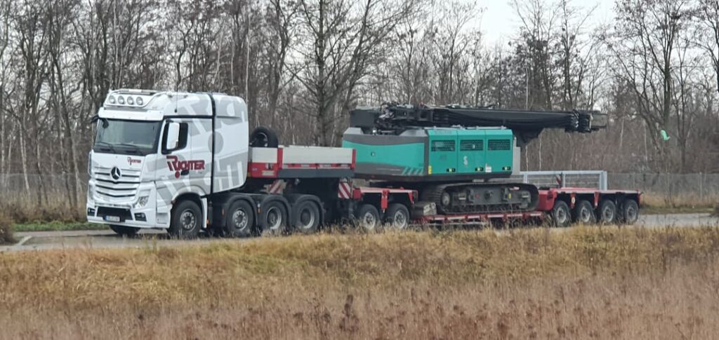 Baumaschinentransport eines Raupenbohrgeräts auf einem modularen Tiefbettauflieger
