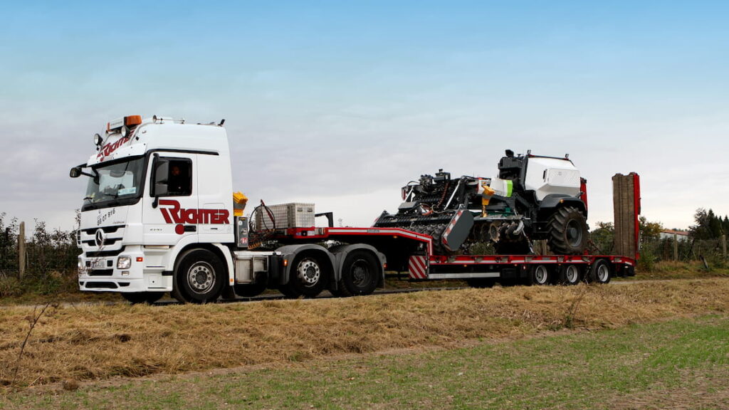 Landmaschinentransport einer selbstfahrenden Feldmaschine auf einem Tieflader