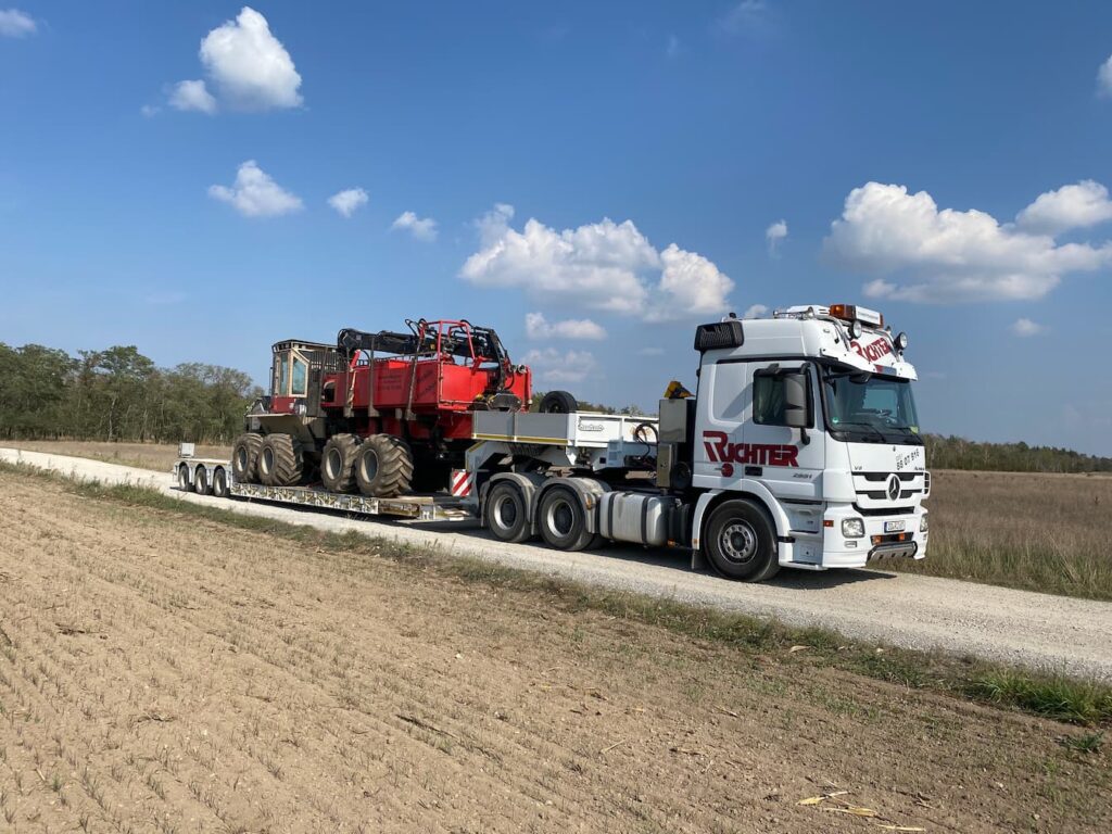 Landmaschinentransport einer Forstmaschine auf einem Tiefbettauflieger