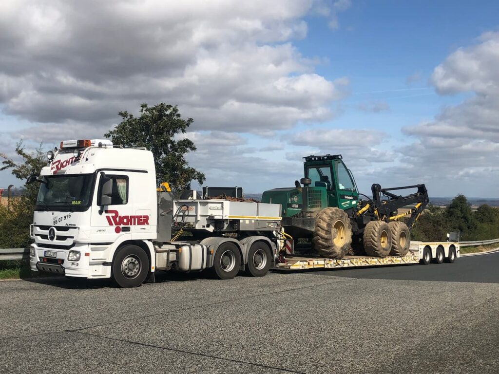 Landmaschinentransport einer Forstmaschine auf einem Tiefbettauflieger