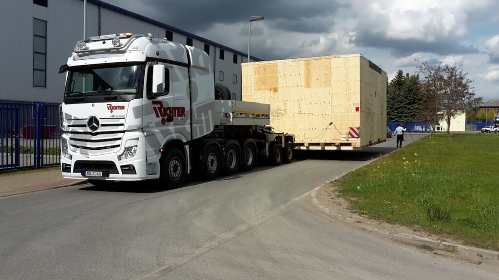 Spezialtransport einer überbreiten Maschinenkiste auf einem Tieflader