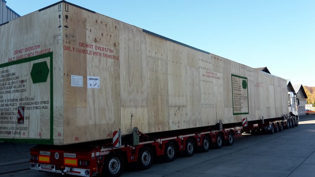 Spezialtransport einer großen Maschinenkiste auf einem modularen Schwerlastauflieger