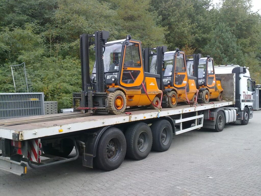 Staplertransport von drei Gabelstaplern auf einem Sattelauflieger