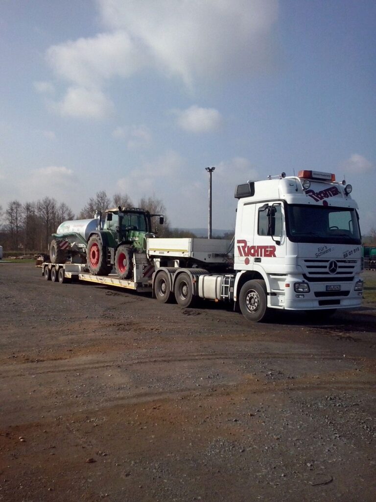 Landmaschinentransport eines Traktors mit Güllefass auf einem Tieflader