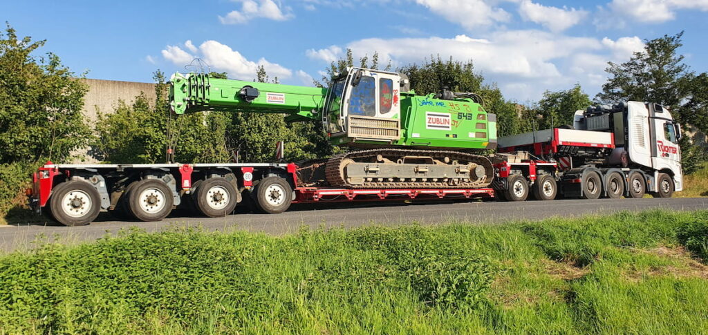 Baumaschinentransport eines Raupenkrans auf einem Tiefbettauflieger