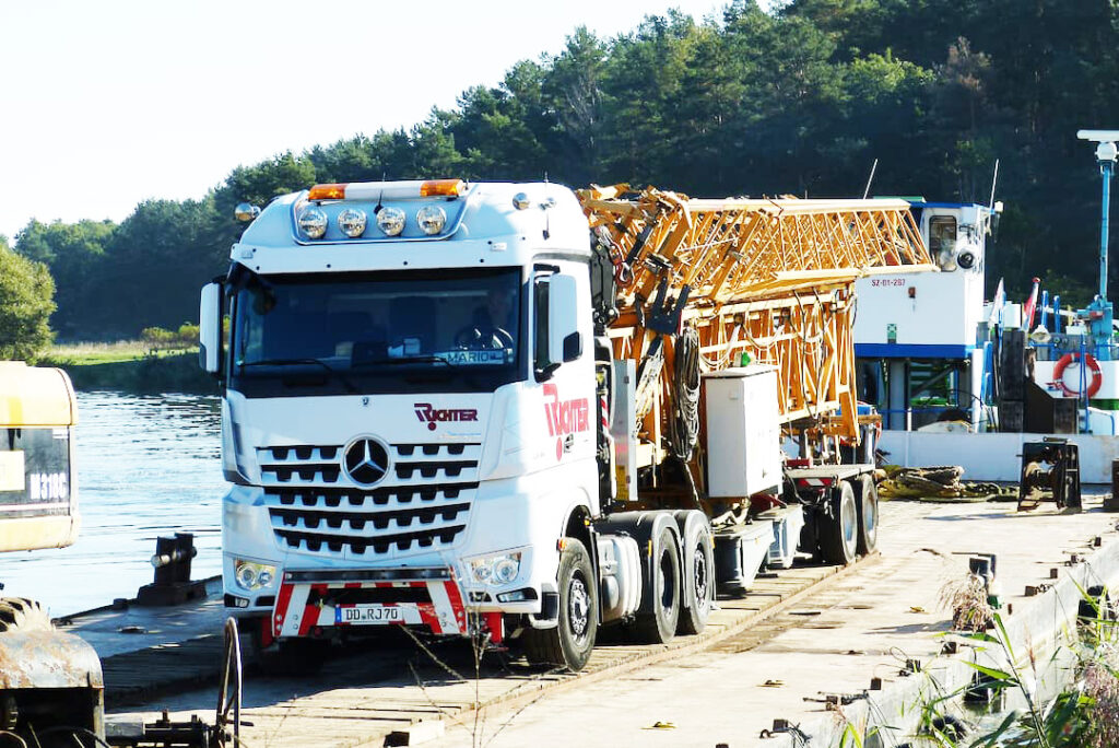 Krantransport eines LIEBHERR Schnellmontagekrans auf einem Spezialfahrzeug am Fähranleger