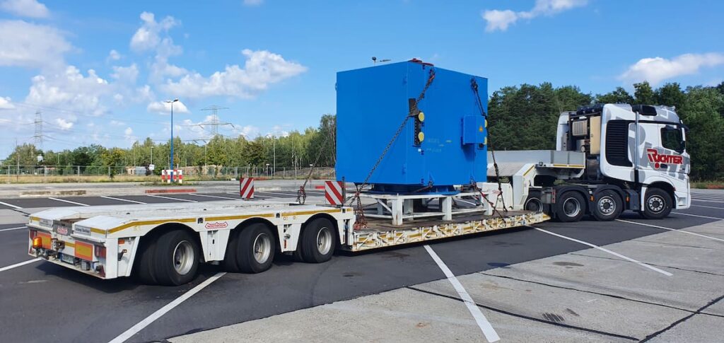 Maschinentransport einer gesicherten Industriemaschine auf einem Tiefbettauflieger