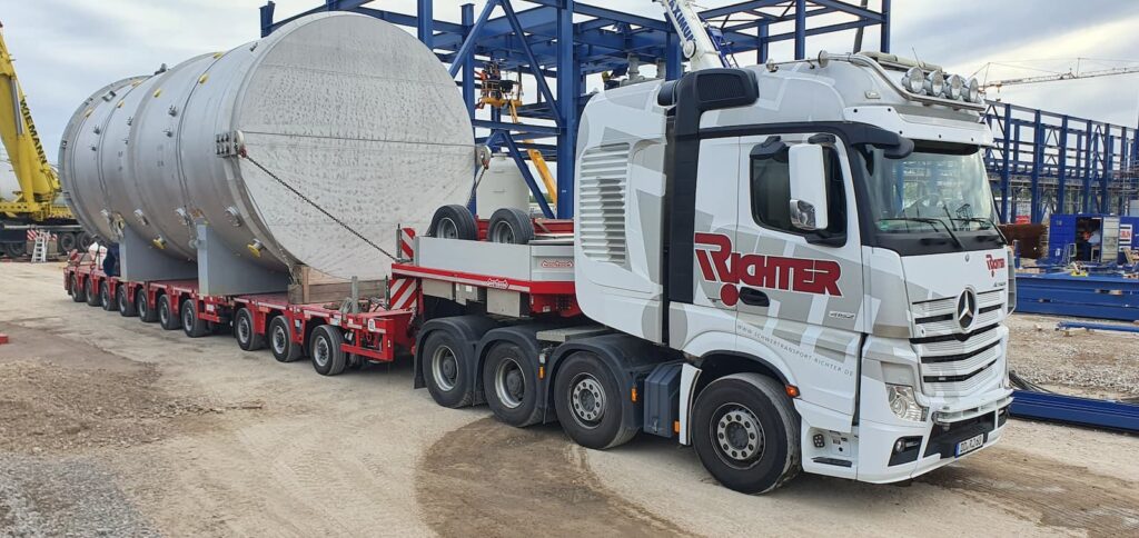 Maschinentransport eines großen Industriebehälters auf einem modularen Schwerlastauflieger