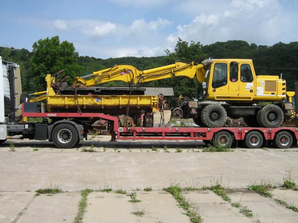 Baggertransport eines Zweiwegebaggers auf einem Tieflader
